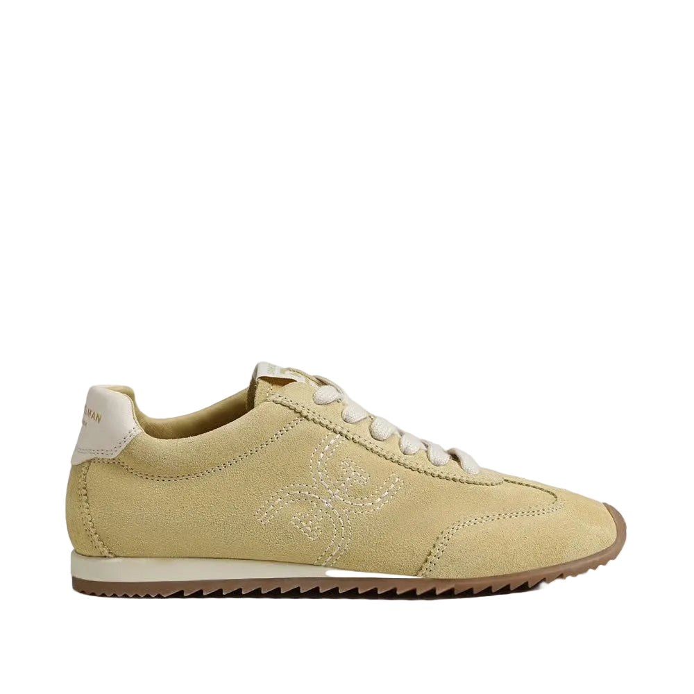 A beige suede sneaker with white laces, a white heel tab, and a brown gum outsole, shown in profile against a light gray background.