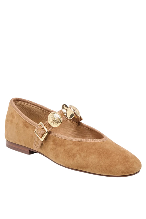 A tan suede Mary Jane flat shoe with gold-tone decorative hardware and a pointed toe, shown on a light gray background.