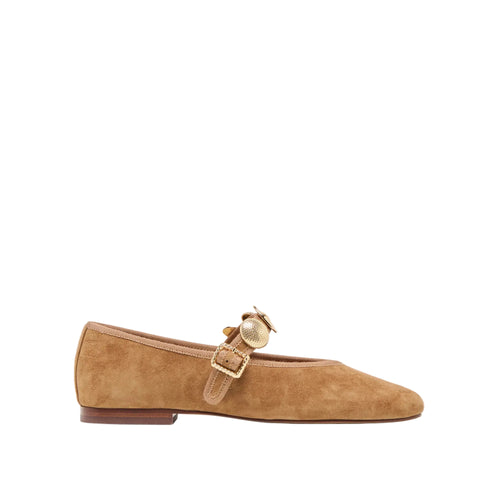 Tan suede flat shoe with a gold buckle on a white background