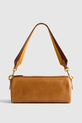 A tan leather shoulder bag with a matching top zipper, gold-tone hardware, and a dual-tone brown and tan shoulder strap, shown against a light gray background.