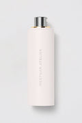 White cylindrical container with silver cap on a light gray background