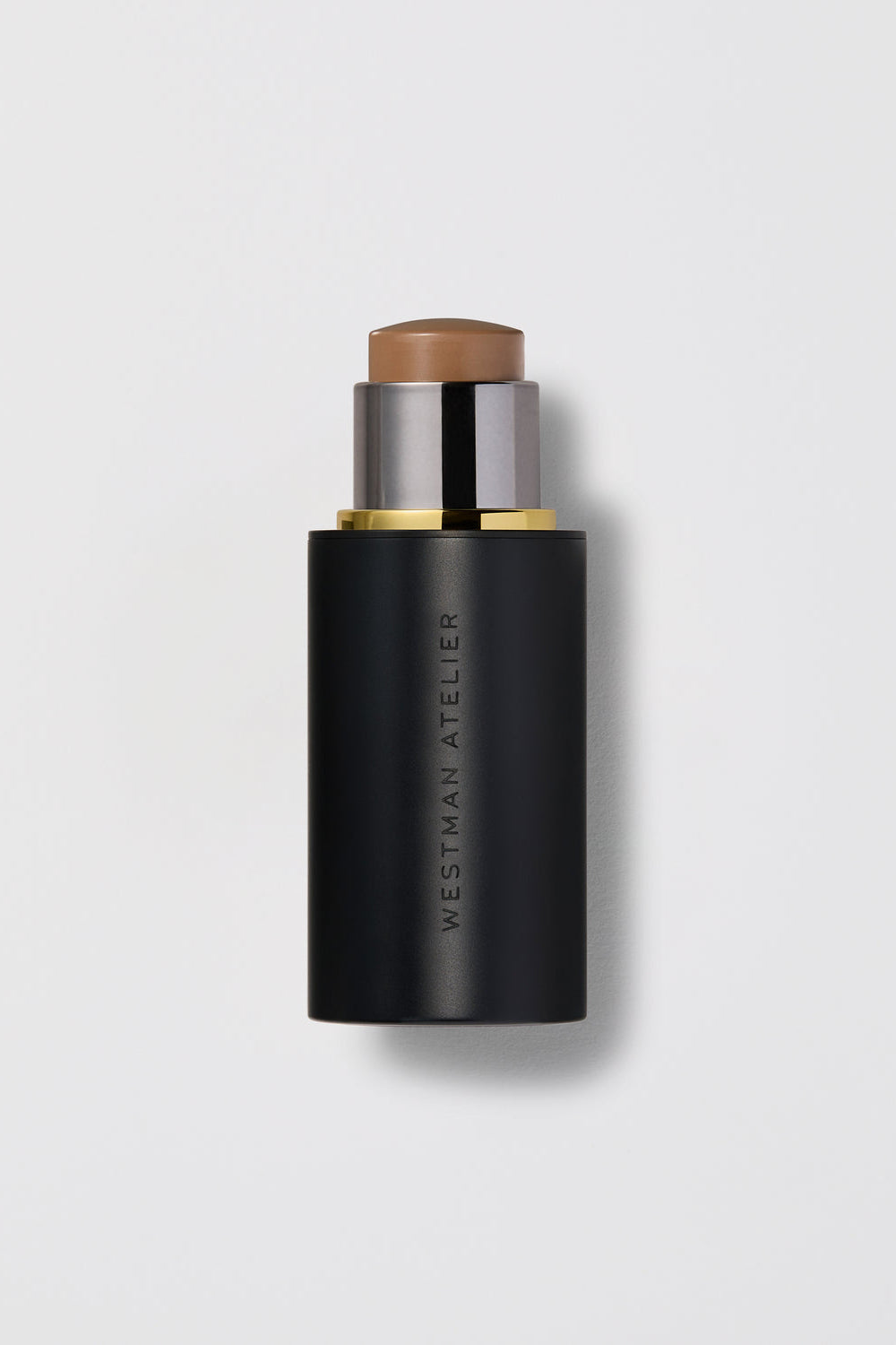 Black cosmetic stick with brown top on a light gray background