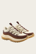 A pair of rugged platform sneakers in cream, brown, and beige, featuring chunky laces, a thick sole, and Vibram branding on the toe and heel.